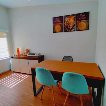 Sala de avaliação com mesa e materiais terapêuticos