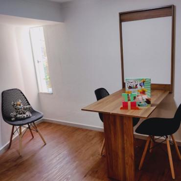 Consultório com mesa de atendimento e poltronas