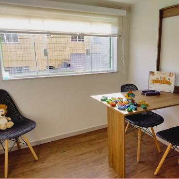 Sala de terapia com mesa e jogos pedagógicos