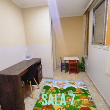 Sala 7, com mesa infantil e tapete lúdico
